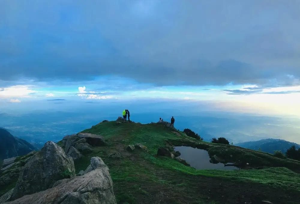 Trekkers on Triund ridge with the Kangra Valley stretching below